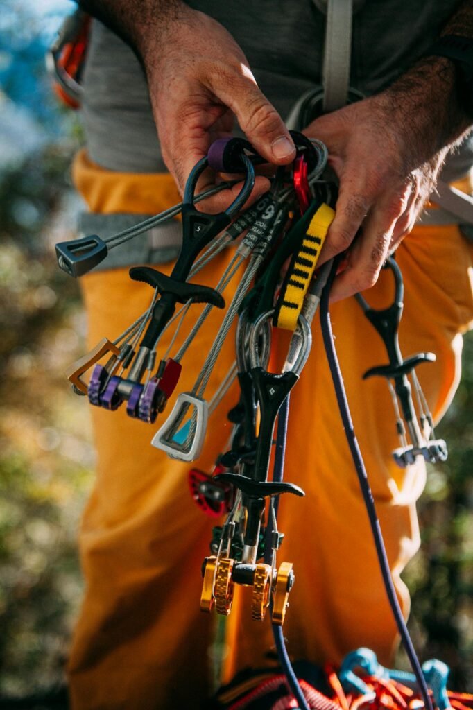 A detailed view of climbing tools and gear being held outdoors.